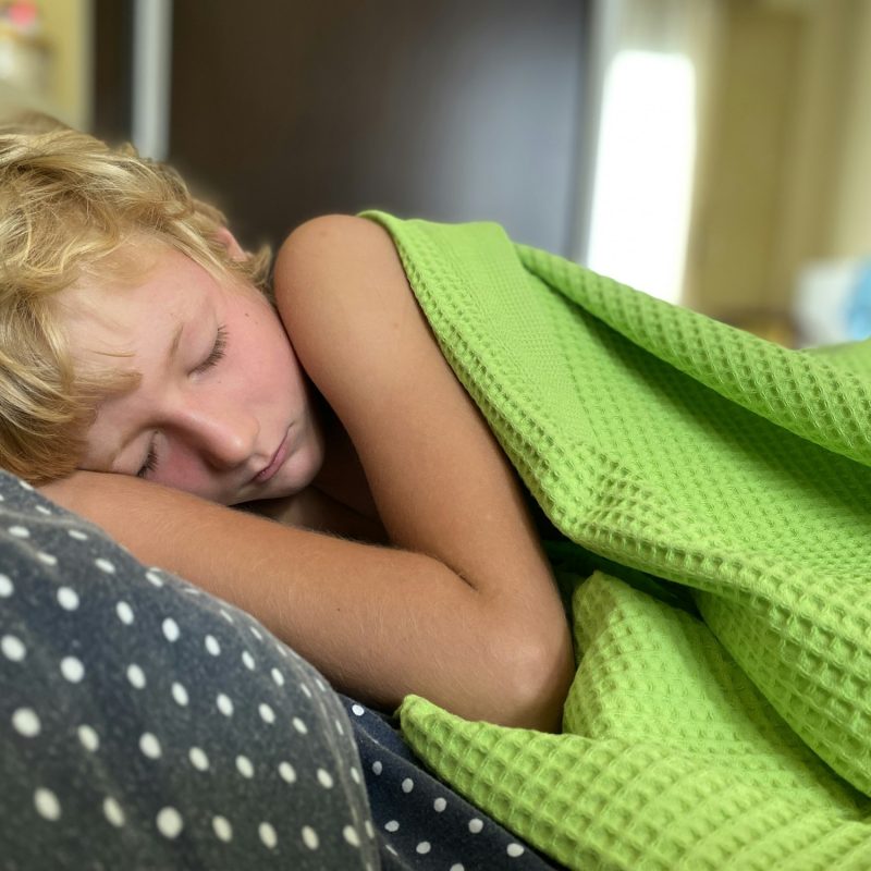 Child sleeping calmly green blanket , healthy sleeping, problem with sleep, insomnia