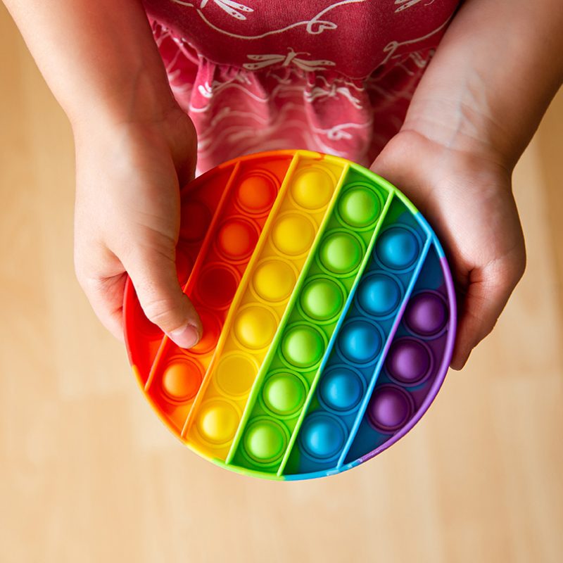 Close up view of child play with rainbow color popular push pop